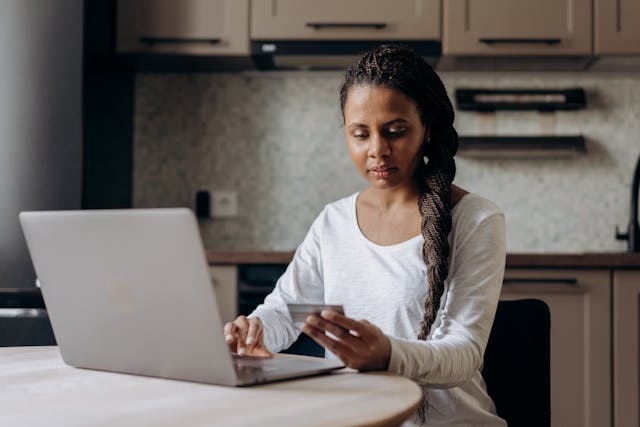 tenant holding a credit card in front of their laptop for an online rent payment